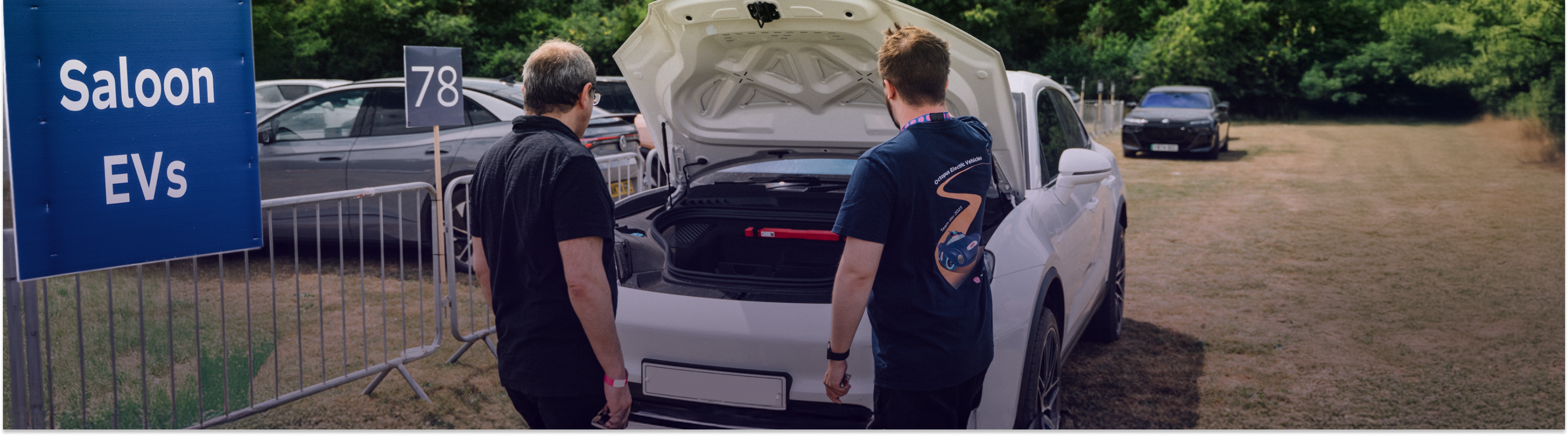Two men looking into the front trunk of a Tesla