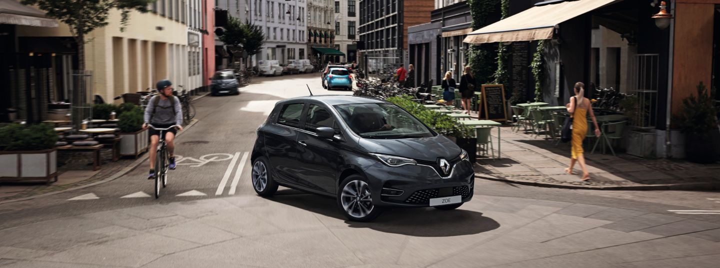 Renault Zoe car turning corner in attractive city suburb