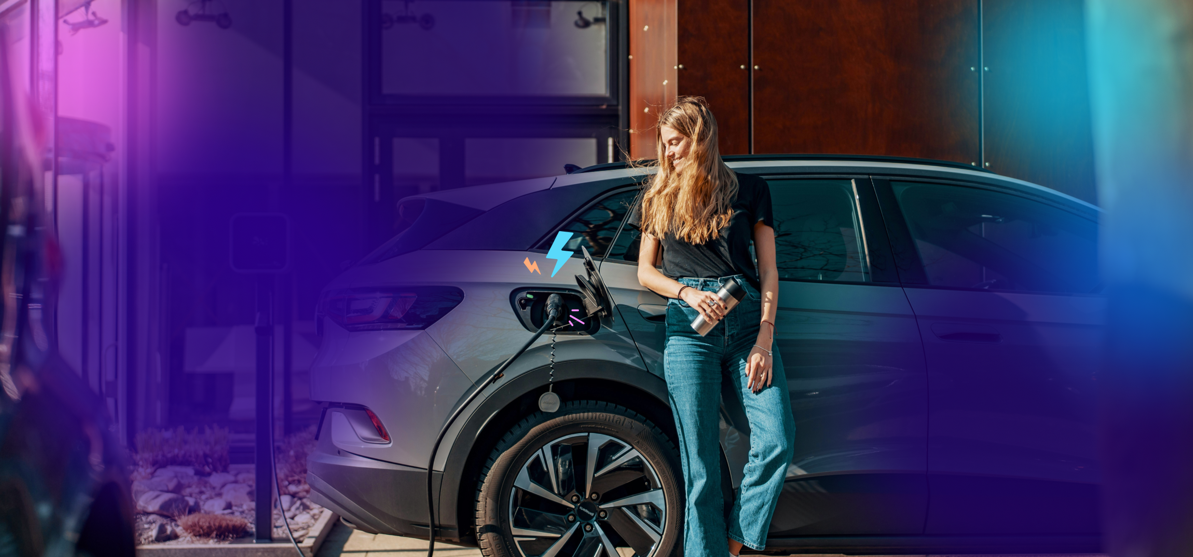 A woman standing beside an electric vehicle on charge
