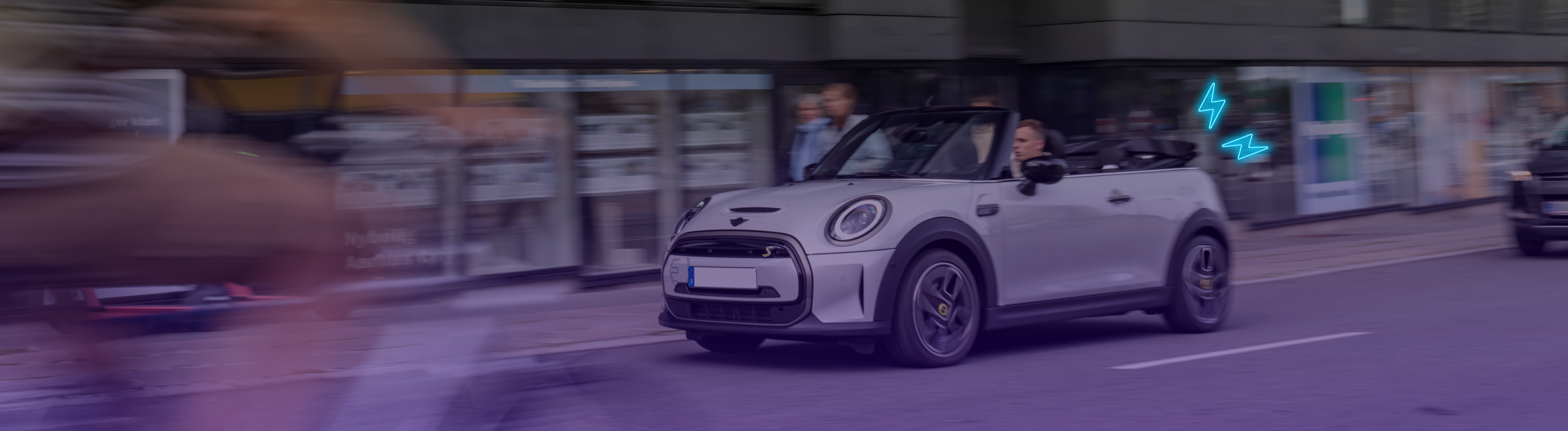 Middle aged man driving a convertible Mini Cooper SE