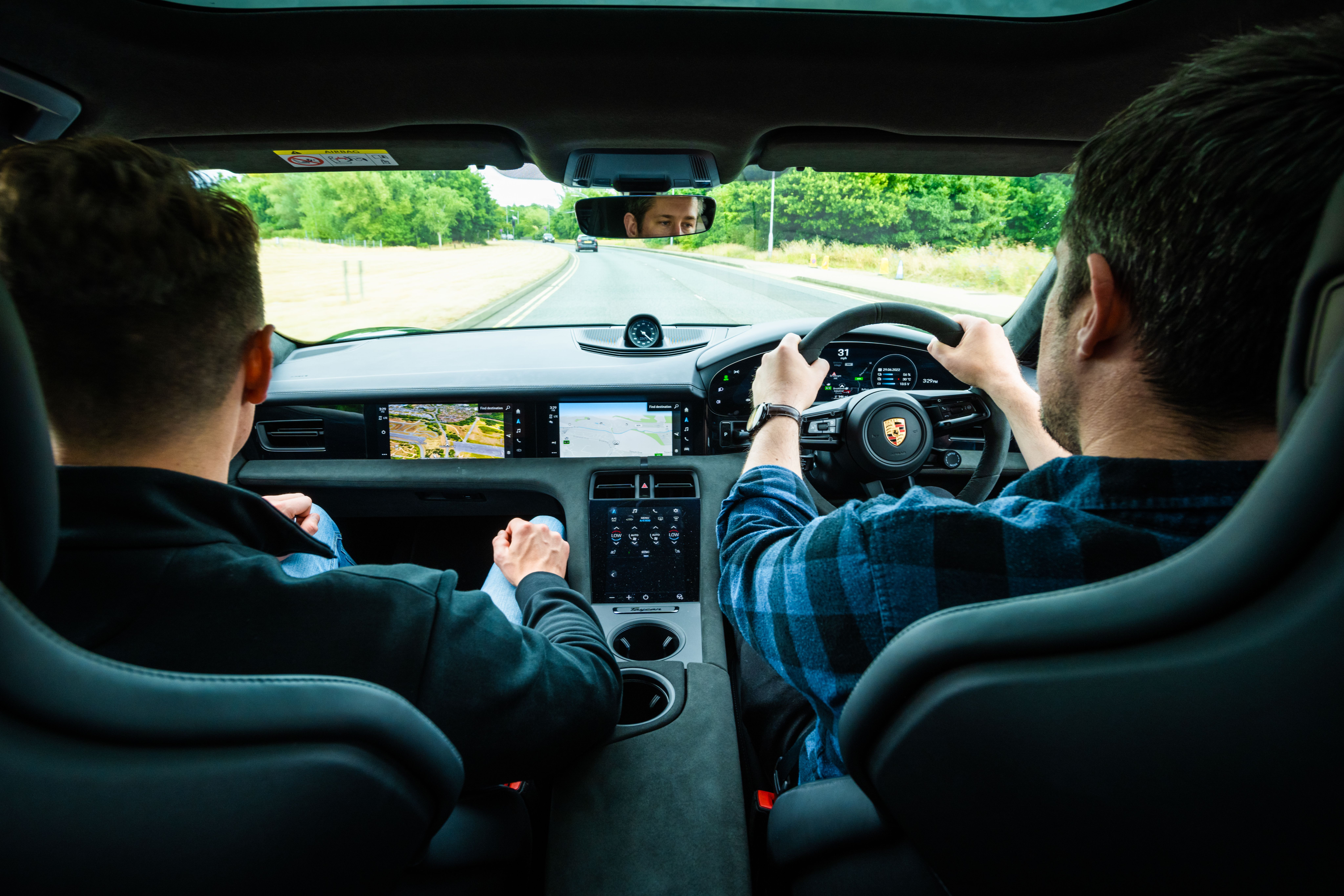 Two men taking a Porsche Taycan for a test drive