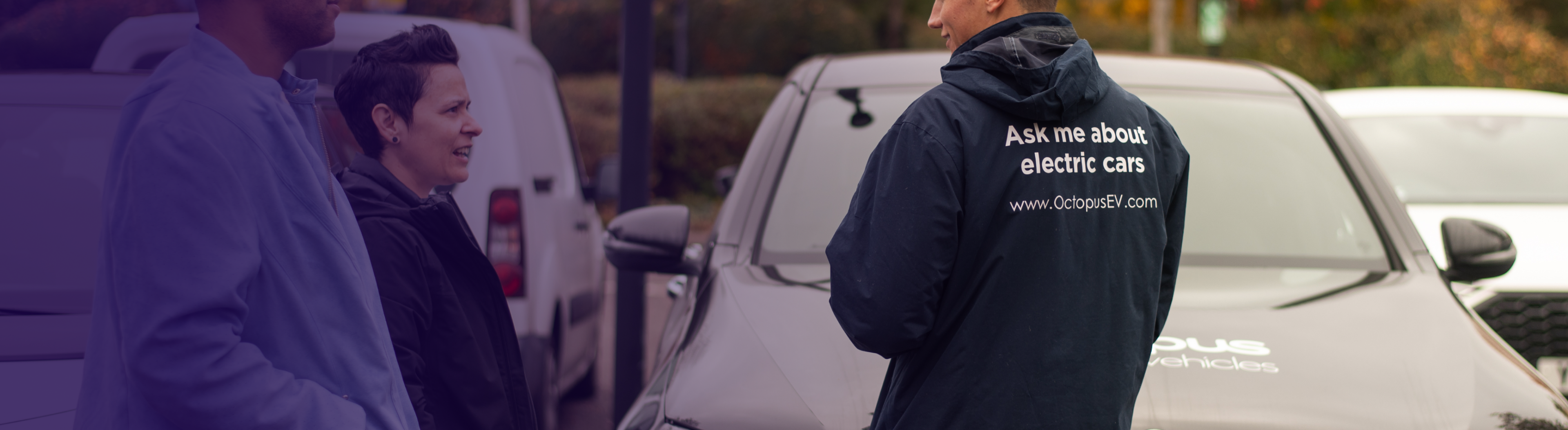 Customers and EV experts talking around an electric vehicle