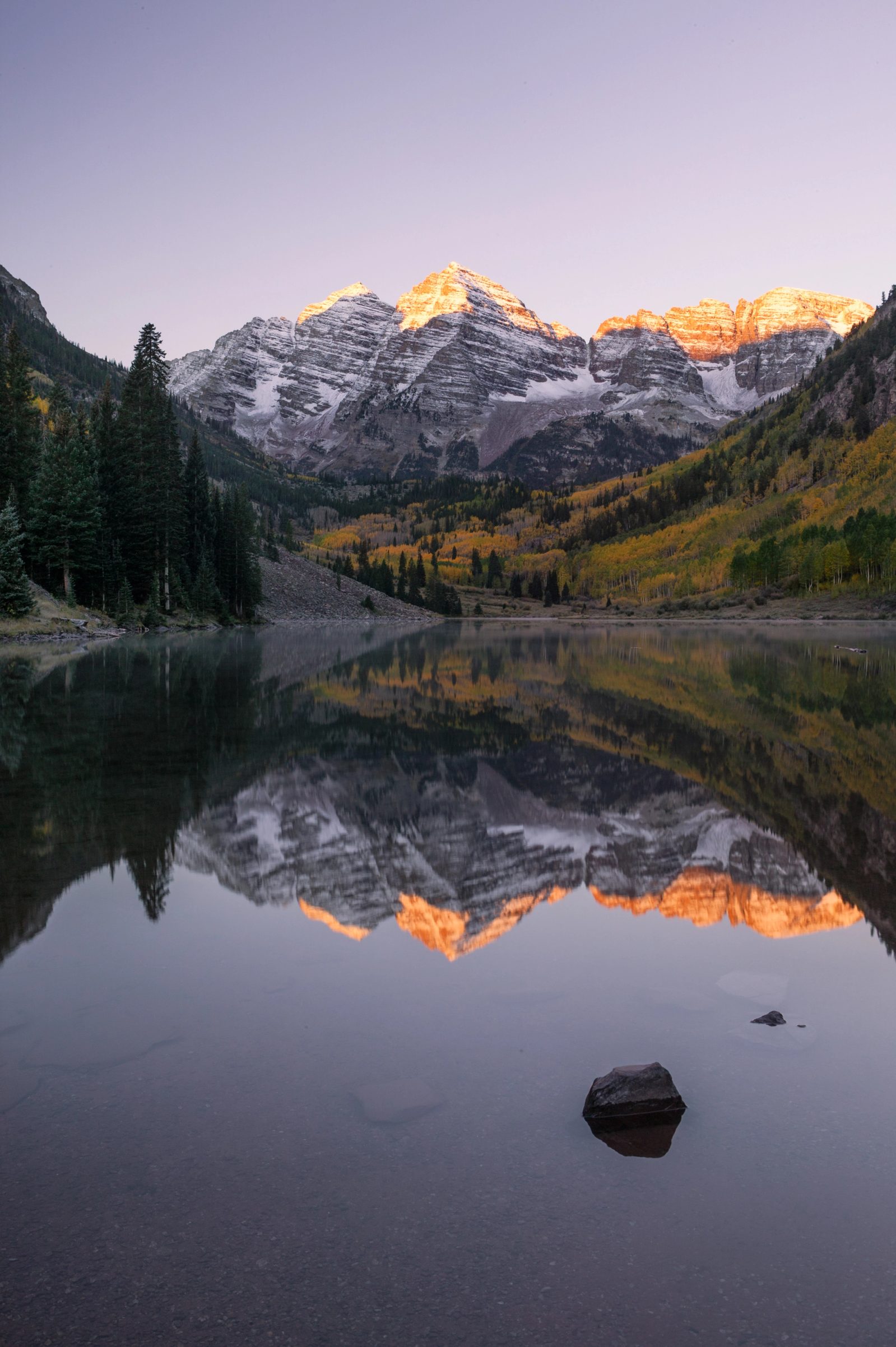 The Maroon Bells reflected in a still lake at dawn, Colorado.