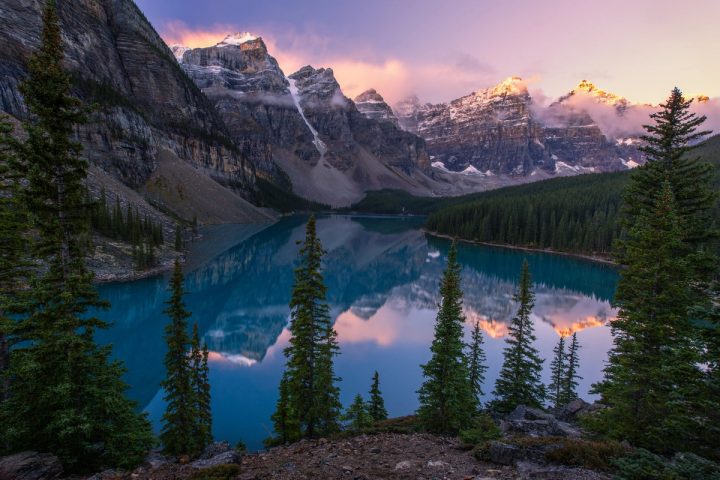 The Ten Peaks catching first light above the turquoise water of Moraine Lake, Banff National Park, Alberta, with a still reflection.
