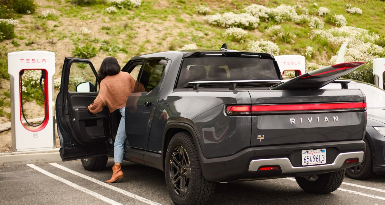 Rivian R1T charging at a Tesla Supercharger station