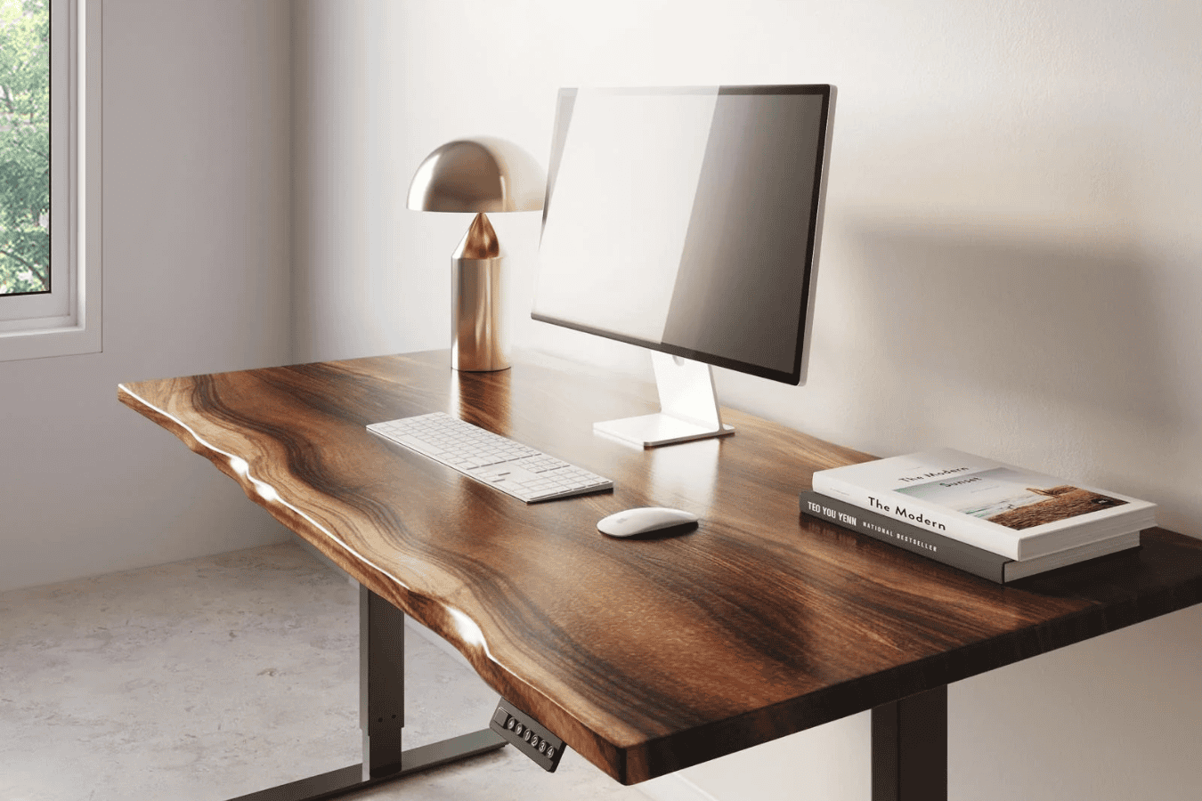 Wooden desk with natural edges, computer setup, lamp, and books by window.