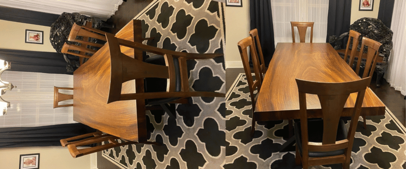 Wooden dining table set with six matching chairs on a patterned black and white rug in a well-lit room with curtains and framed pictures on the walls.