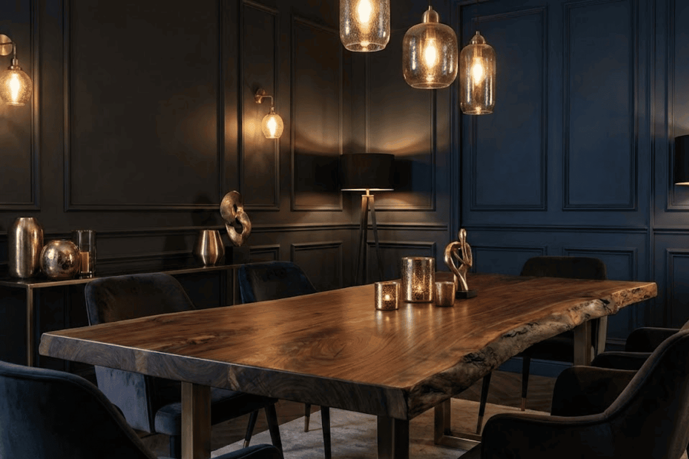 Dark, elegant dining room with a live-edge wooden table, velvet chairs, pendant lights, and warm metallic decor accents
