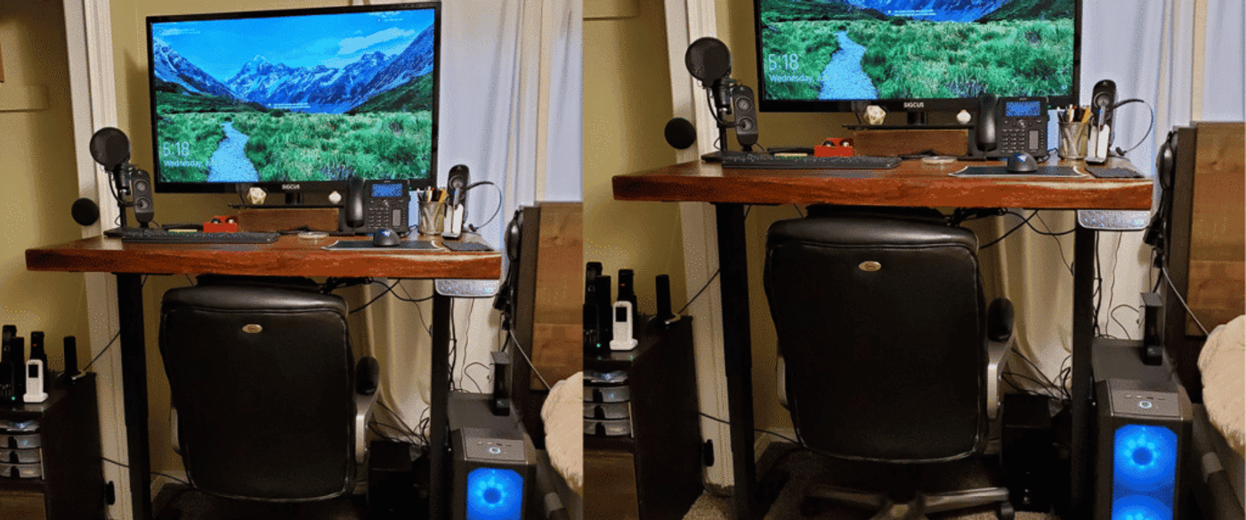 Home desk setup with large monitor, microphone, phone, keyboard, mouse, office chair, and PC tower with blue-lit fans.
