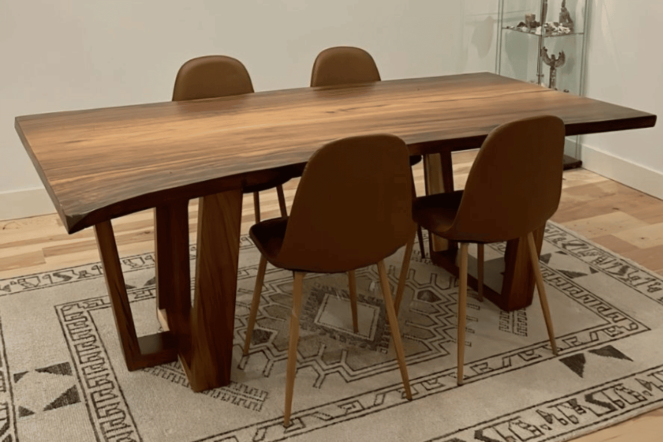 Live-edge walnut dining table with rich wood grain and black metal legs in a modern kitchen