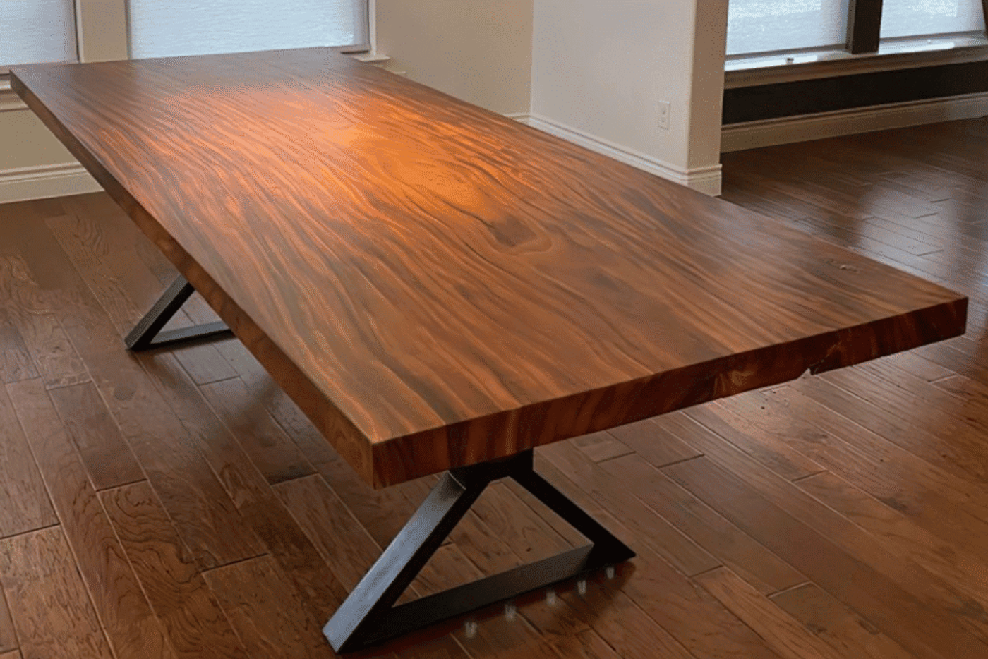 Solid wood dining table with metal legs, showcasing natural grain and modern design.