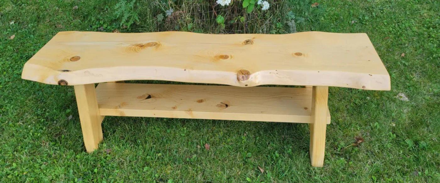 light-wooden-bench-with-natural-edges-and-knots-placed-on-green-grass-outdoors