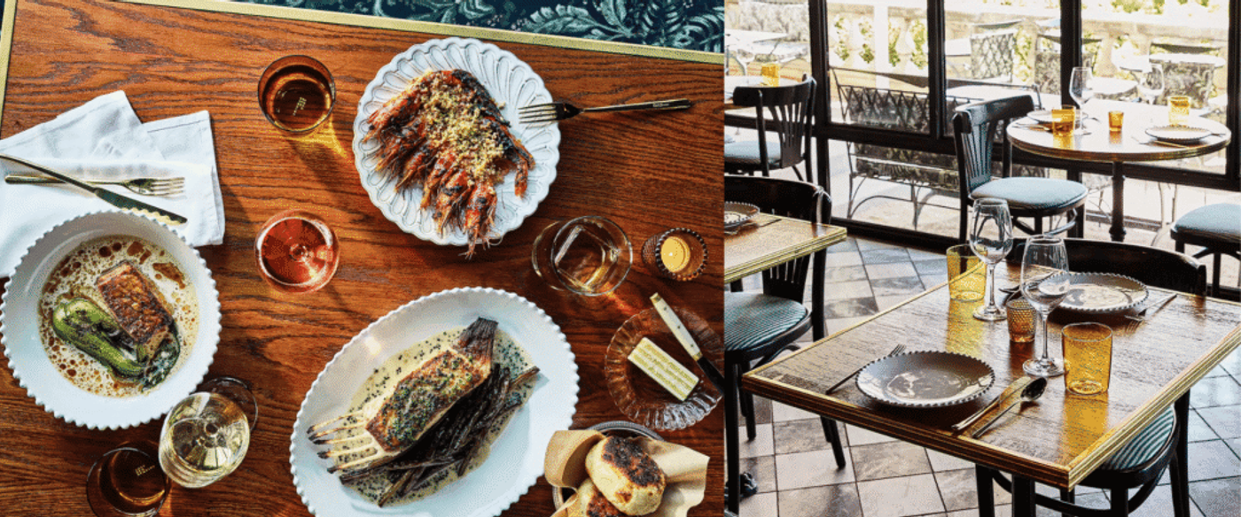 Top view of a wooden dining table with gourmet seafood, grilled fish, wine glasses, bread, and butter for a fine dining meal