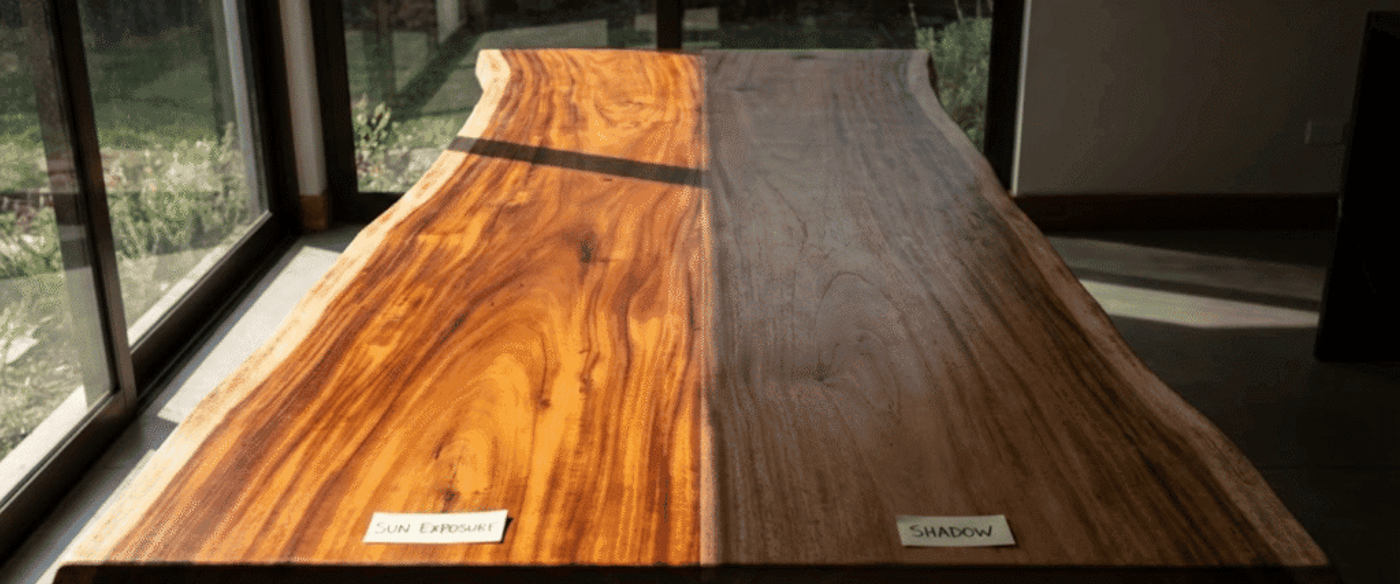 Sunlit live-edge wooden tabletop on left, shadowed natural wood grain on right, two labels reading Sun Exposure and Shadow