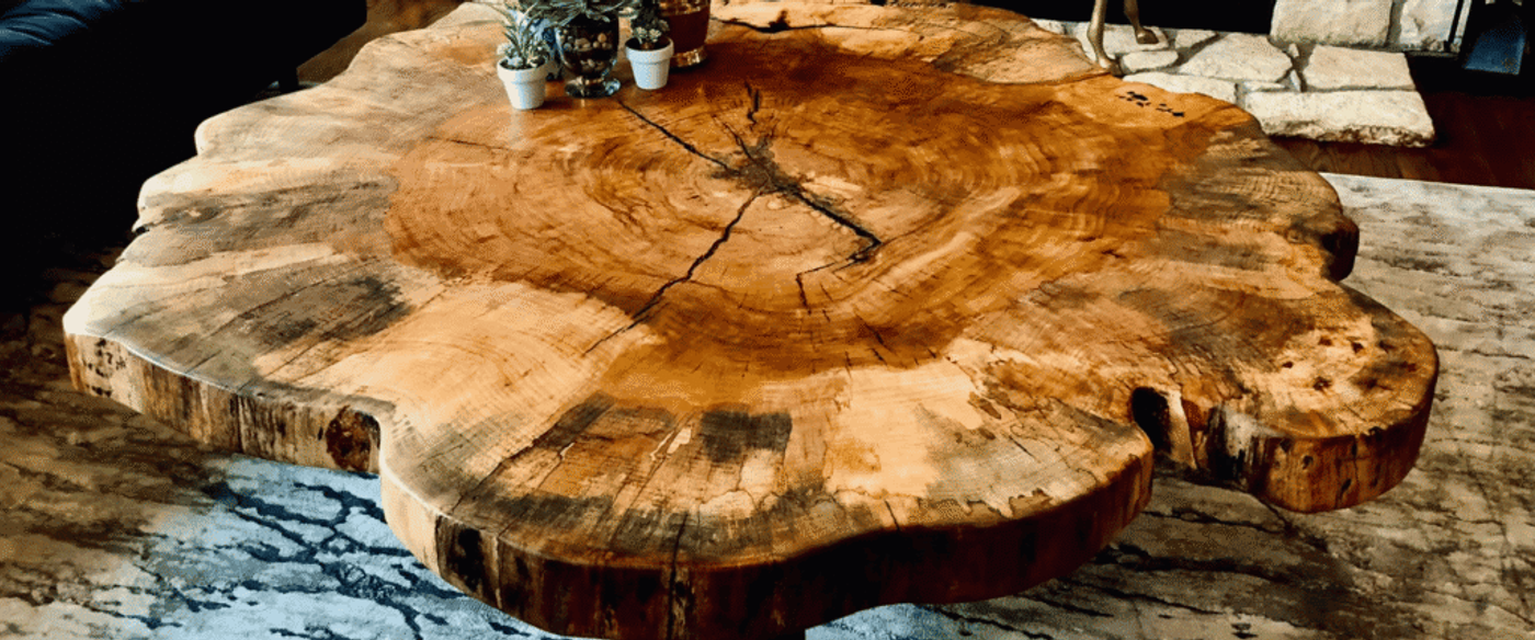 Round live edge wood cookie slab coffee table showing natural growth rings and rustic grain patterns