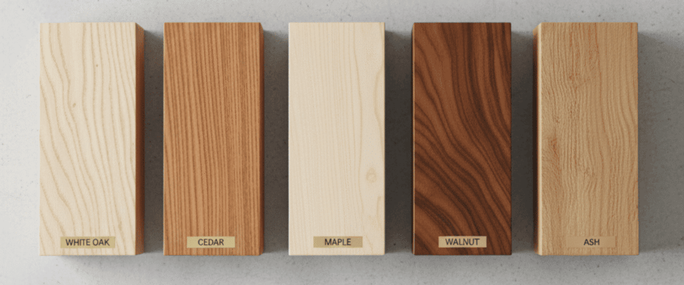 Five rectangular wood samples labeled White Oak, Cedar, Maple, Walnut, and Ash arranged horizontally on a light gray textured surface.