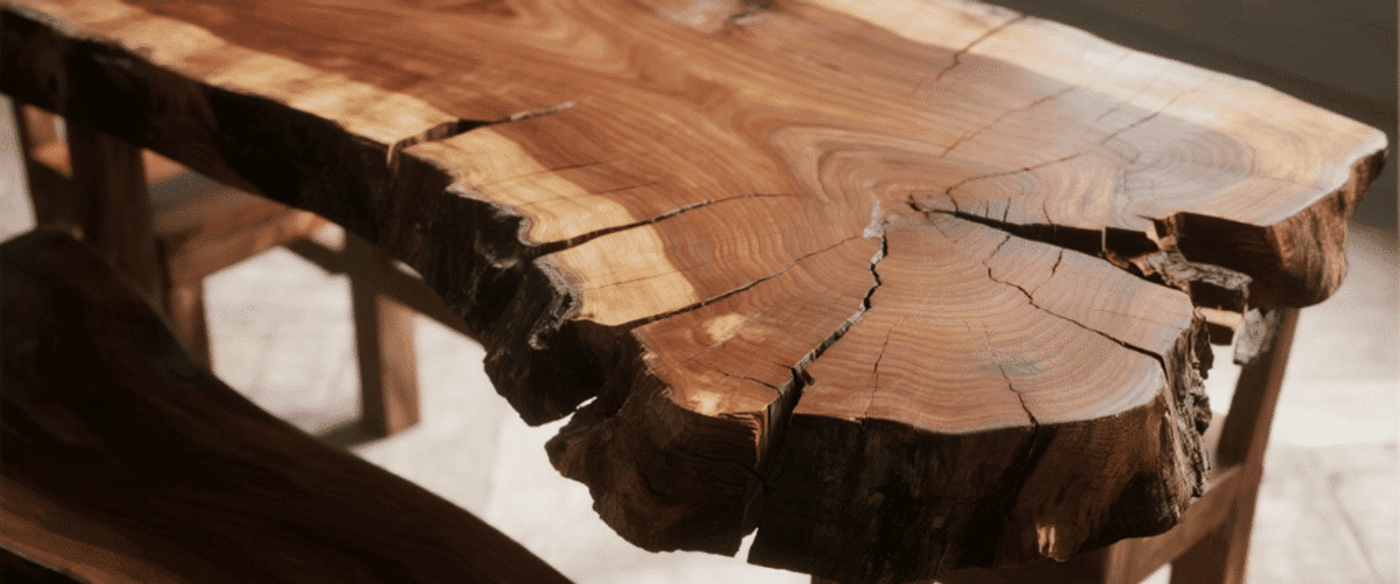 Live-edge wooden table with visible growth rings and natural cracks