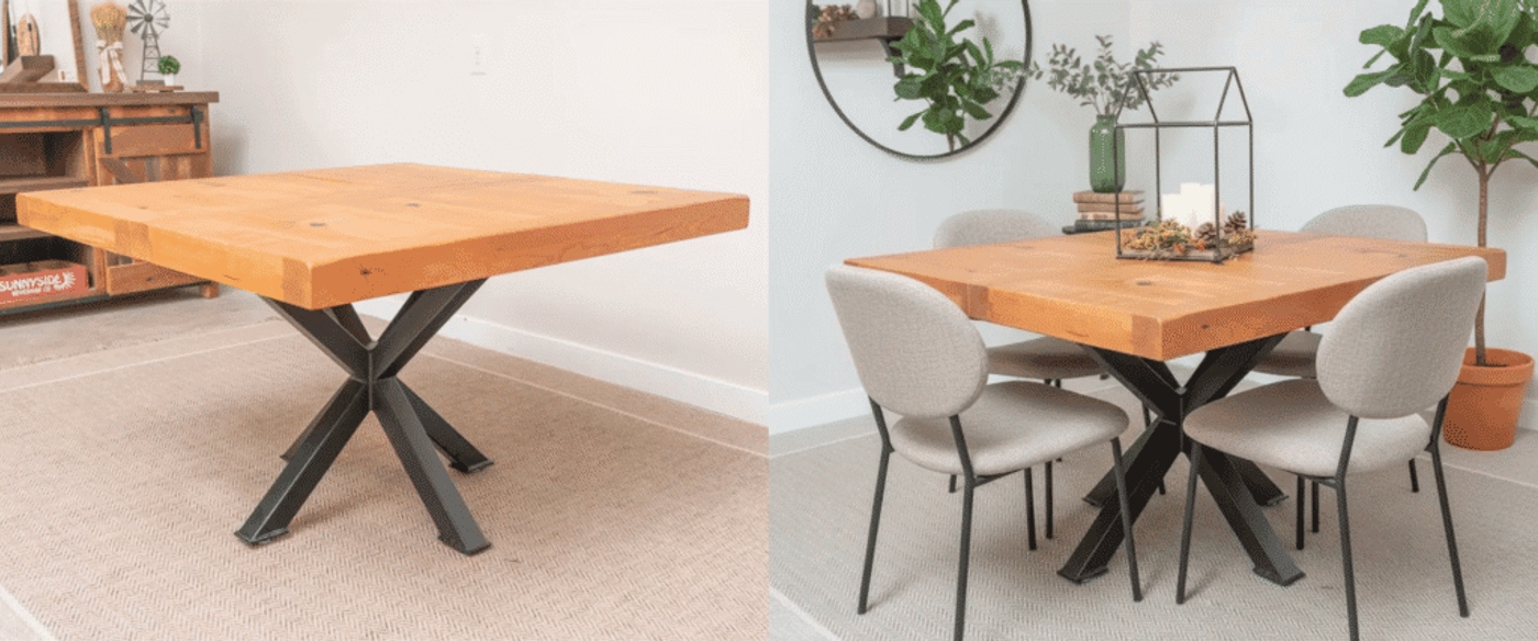 Cherry wood square dining table with thick top and black metal X-base, set with four dark chairs and centerpiece.