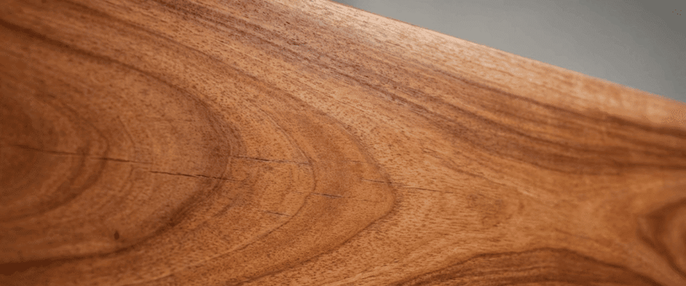 Warm, richly grained Guanacaste wood slab with natural rings and a small engraved