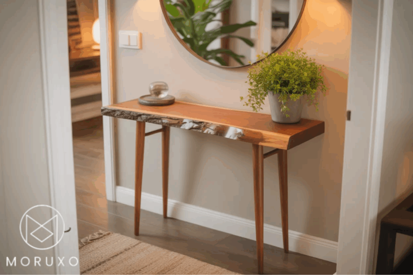 Wooden console table with natural edge, slim legs, small plant pot, round wall mirror above, in a cozy hallway.