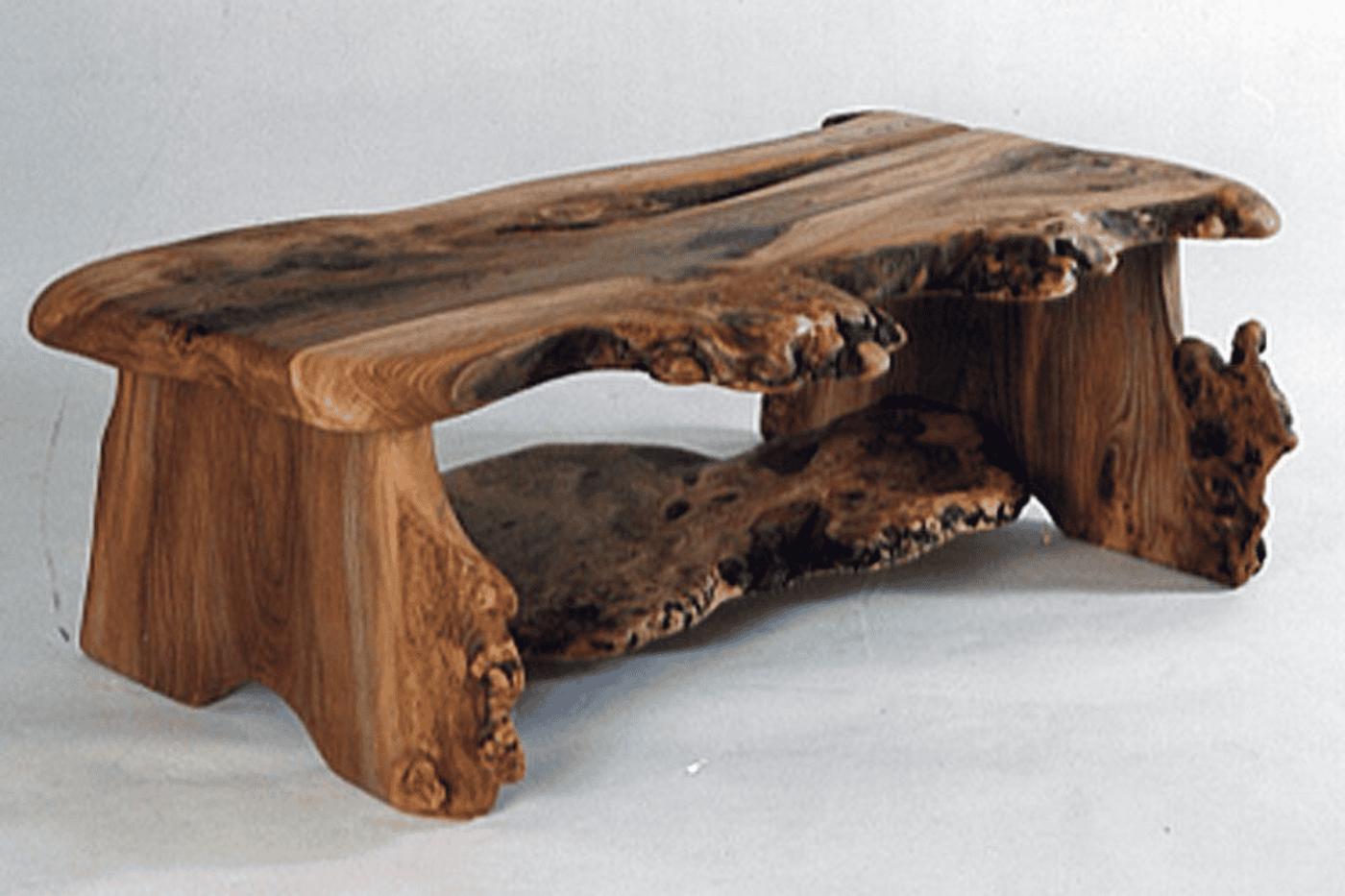 Handmade wooden coffee table with natural, irregular edges and a lower shelf, showcasing rustic and organic design