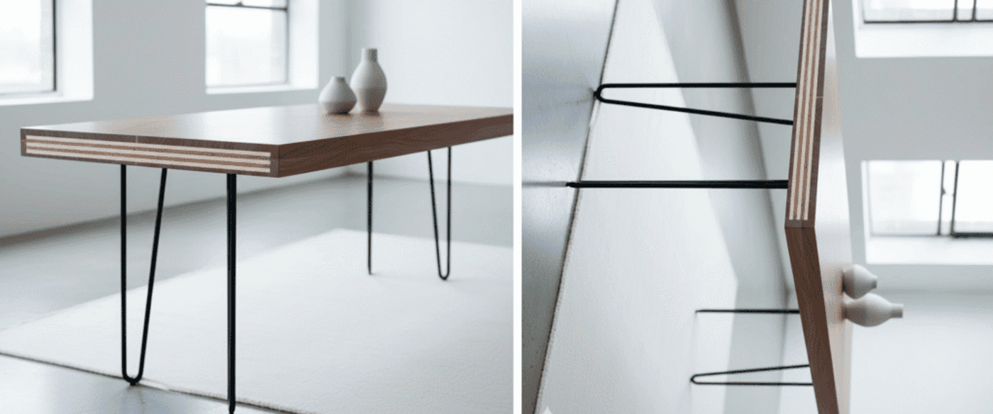 Minimal walnut dining table with exposed laminated edge and slender black hairpin legs, two ceramic vases on top, bright modern room