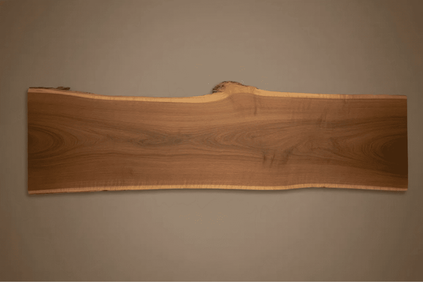 Natural live edge wood slab with smooth finish, showcasing unique grain patterns and organic shape.