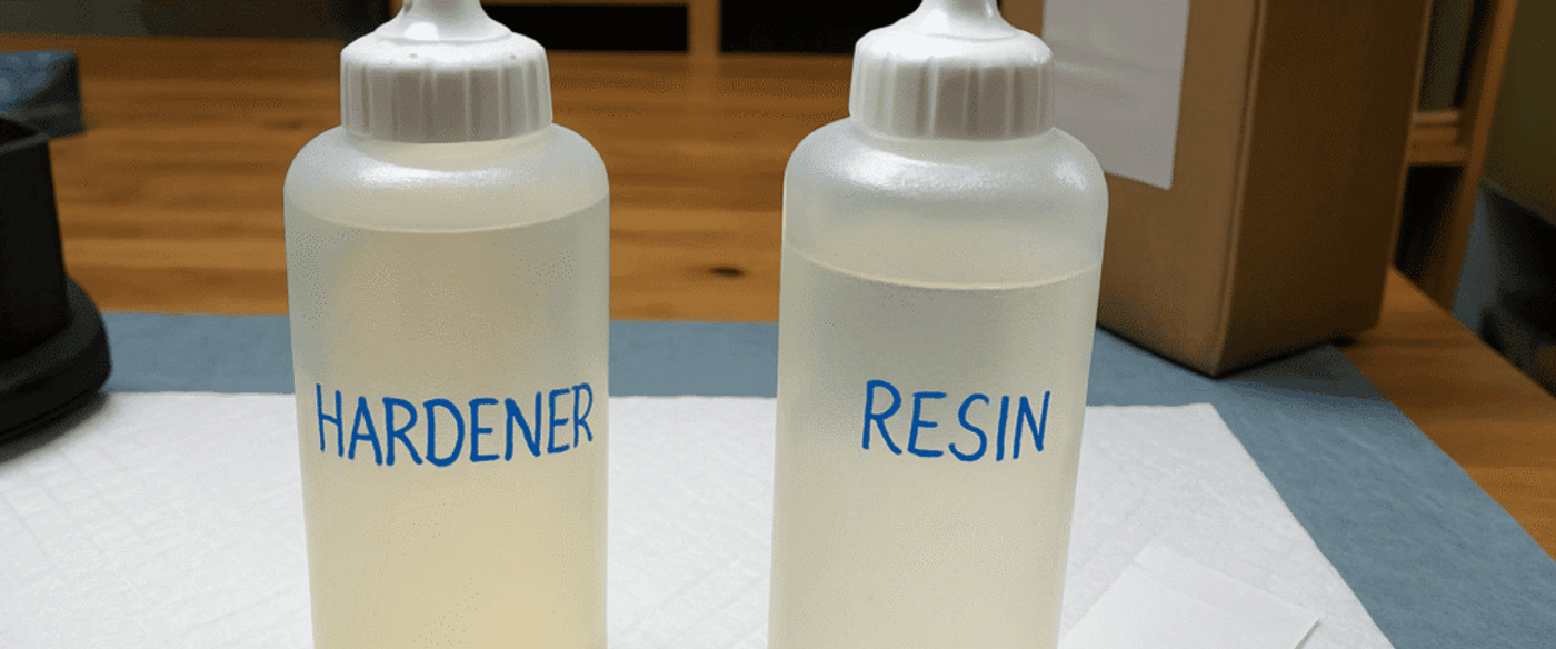 Two-translucent-plastic-squeeze-bottles-labeled-‘HARDENER-and-‘RESIN