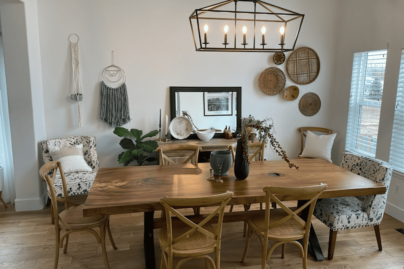 Dining room with a wooden table, mixed chairs, wall decor, and natural light.