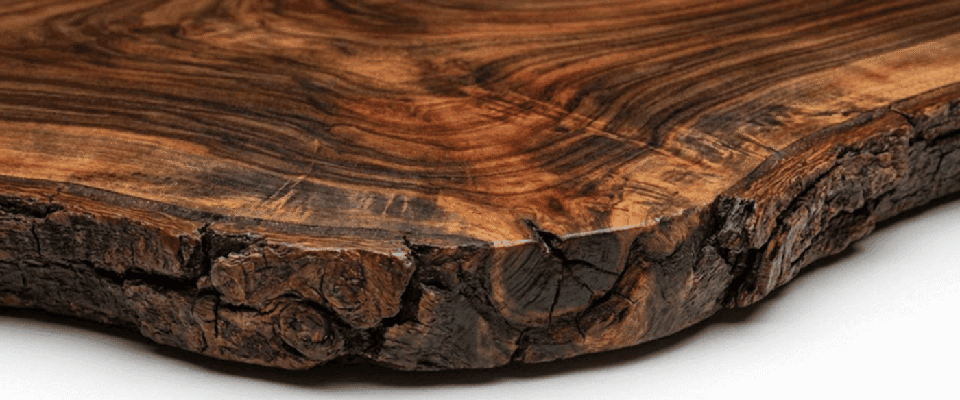 Hand-sanded live-edge walnut slab with rich grain patterns, natural knots, and dark weathered bark along the curved edge