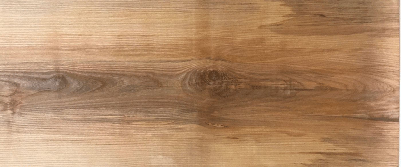 A close-up image of a wooden surface showing natural grain patterns and knots.