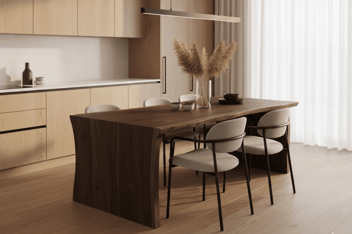 Sunlit modern dining area with a dark wood table, four cushioned chairs, pampas grass centerpiece, and light wood kitchen cabinets