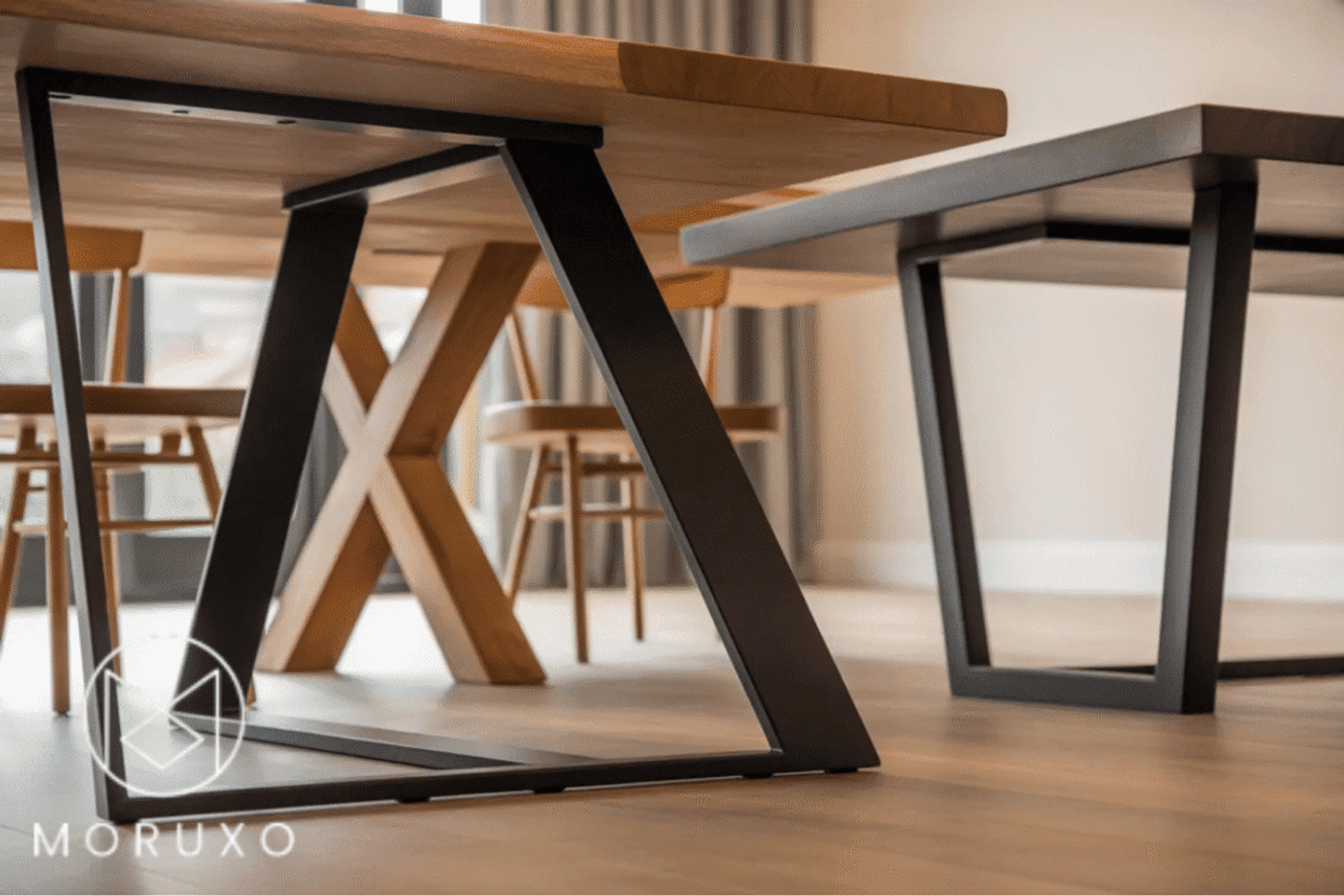 Modern wooden tables with black metal legs, showcasing a mix of sleek and rustic design in a bright room.