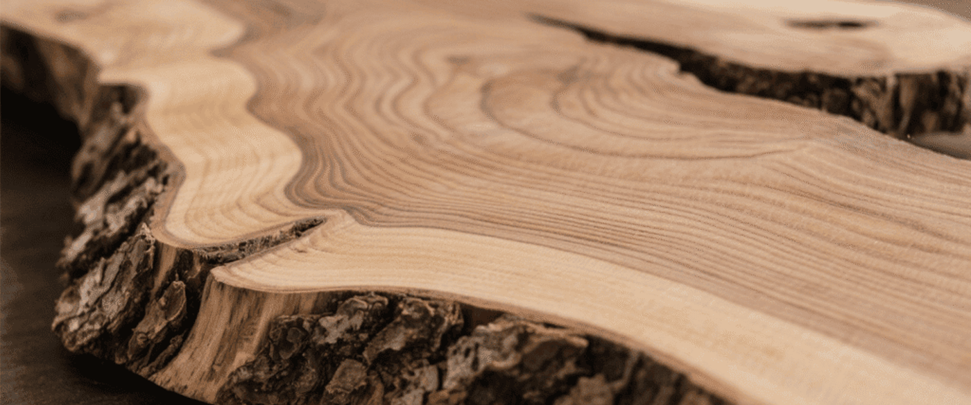 Rustic live-edge wood slab showing natural bark and growth rings, ideal for tables, countertops, or decor.