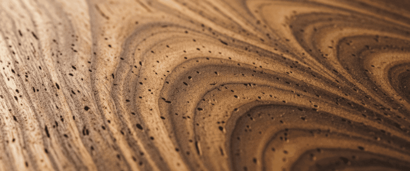 Guanacaste wood board with bold cathedral grain patterns — flame-like arches across the surface