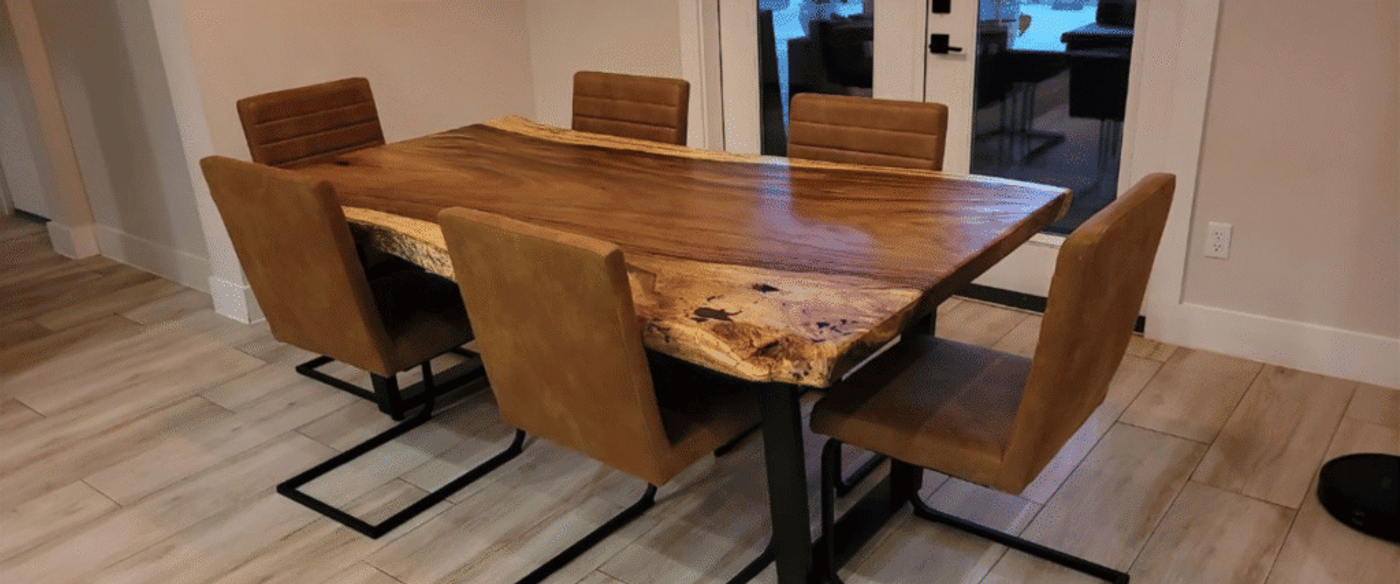 Wooden live-edge dining table with six brown upholstered chairs on a light tiled floor