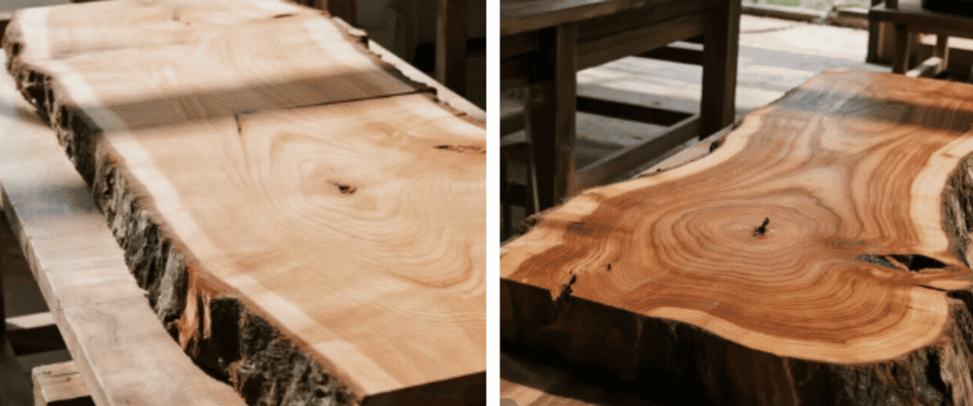 Live-edge wooden table slab with visible growth rings and natural bark, smooth polished surface in a rustic workshop setting.