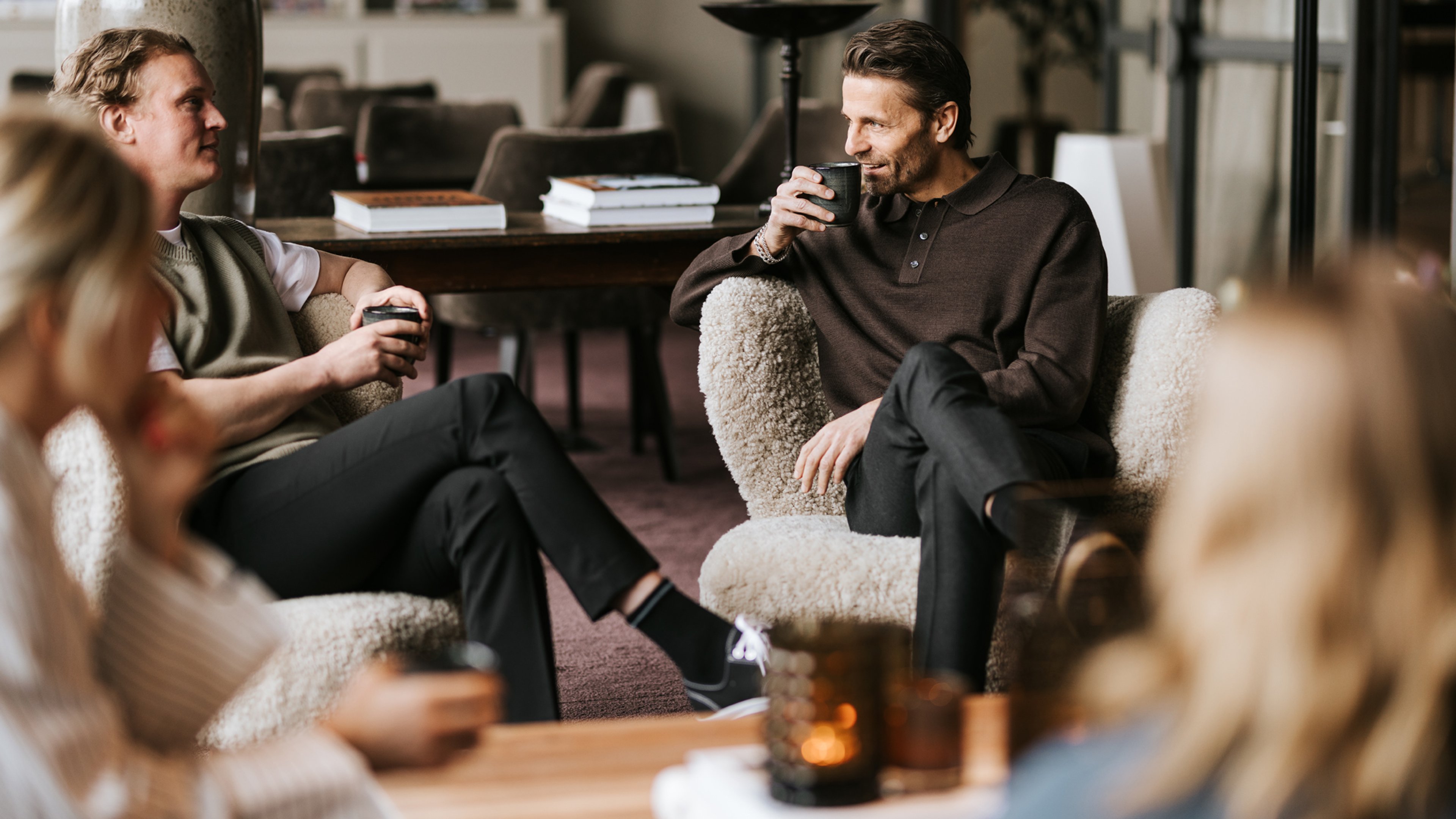 personer som sitter i fåtöljer och dricker kaffe