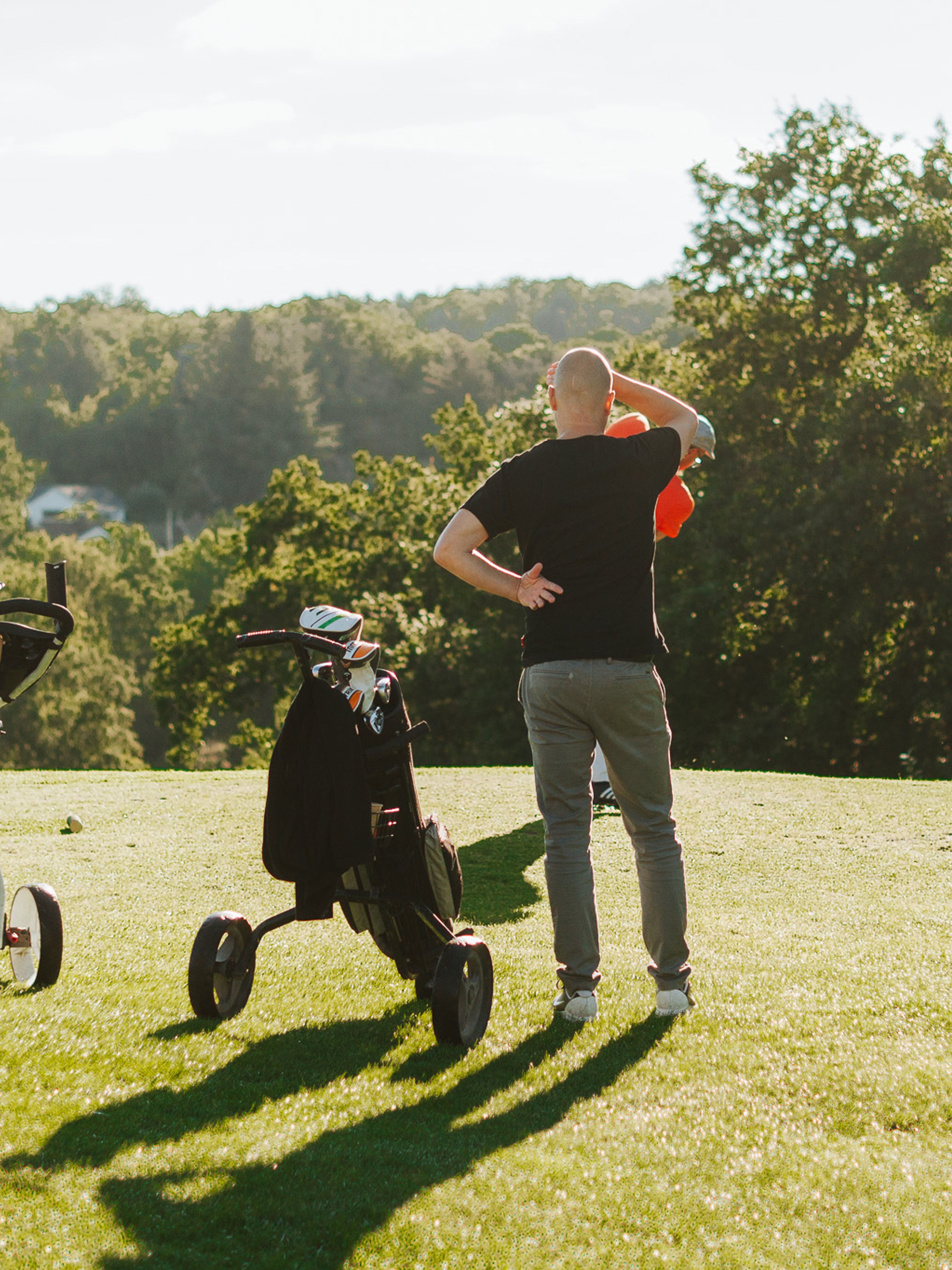 Man som står på golfbanan och kollar ut över banan