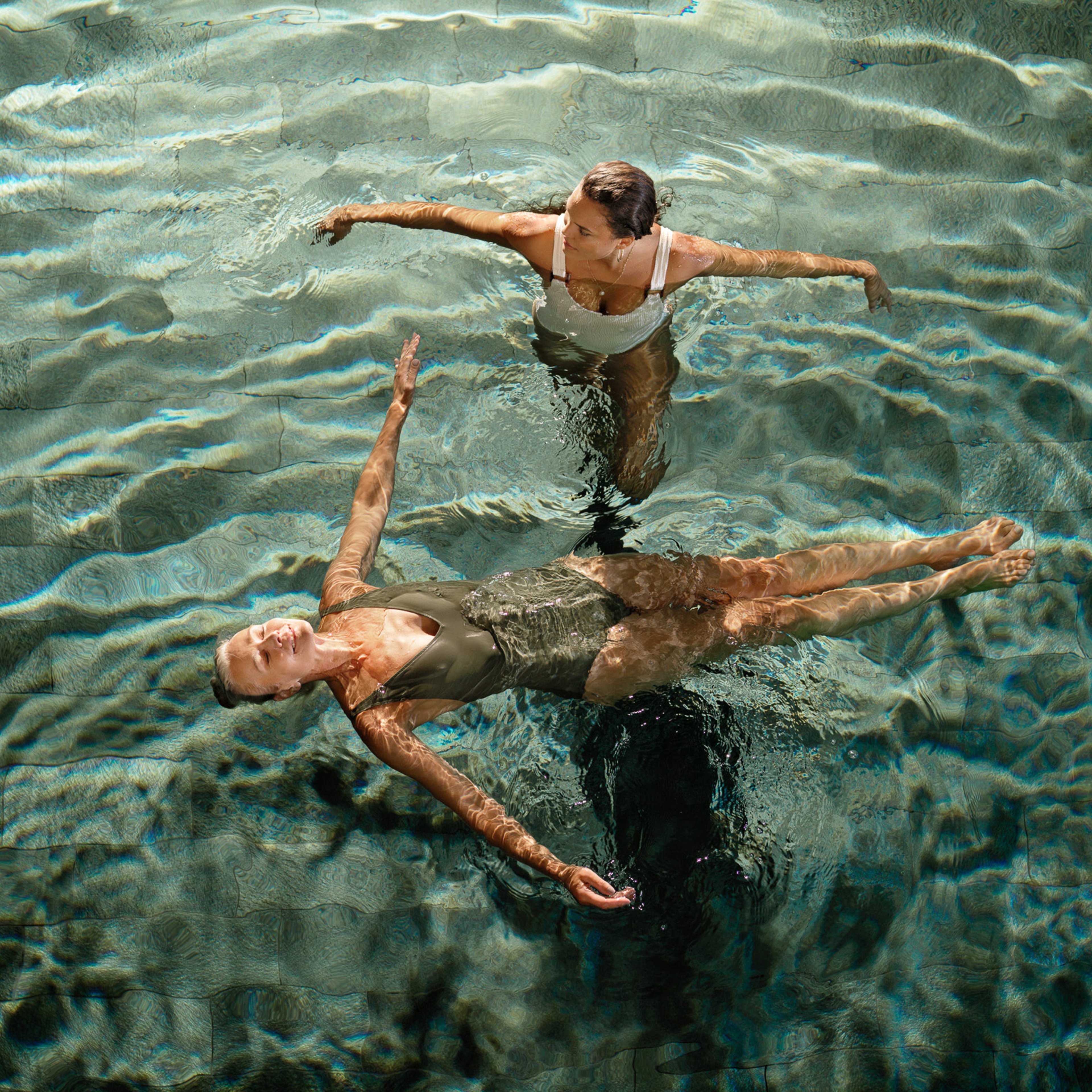 Två kvinnor som badar i en pool