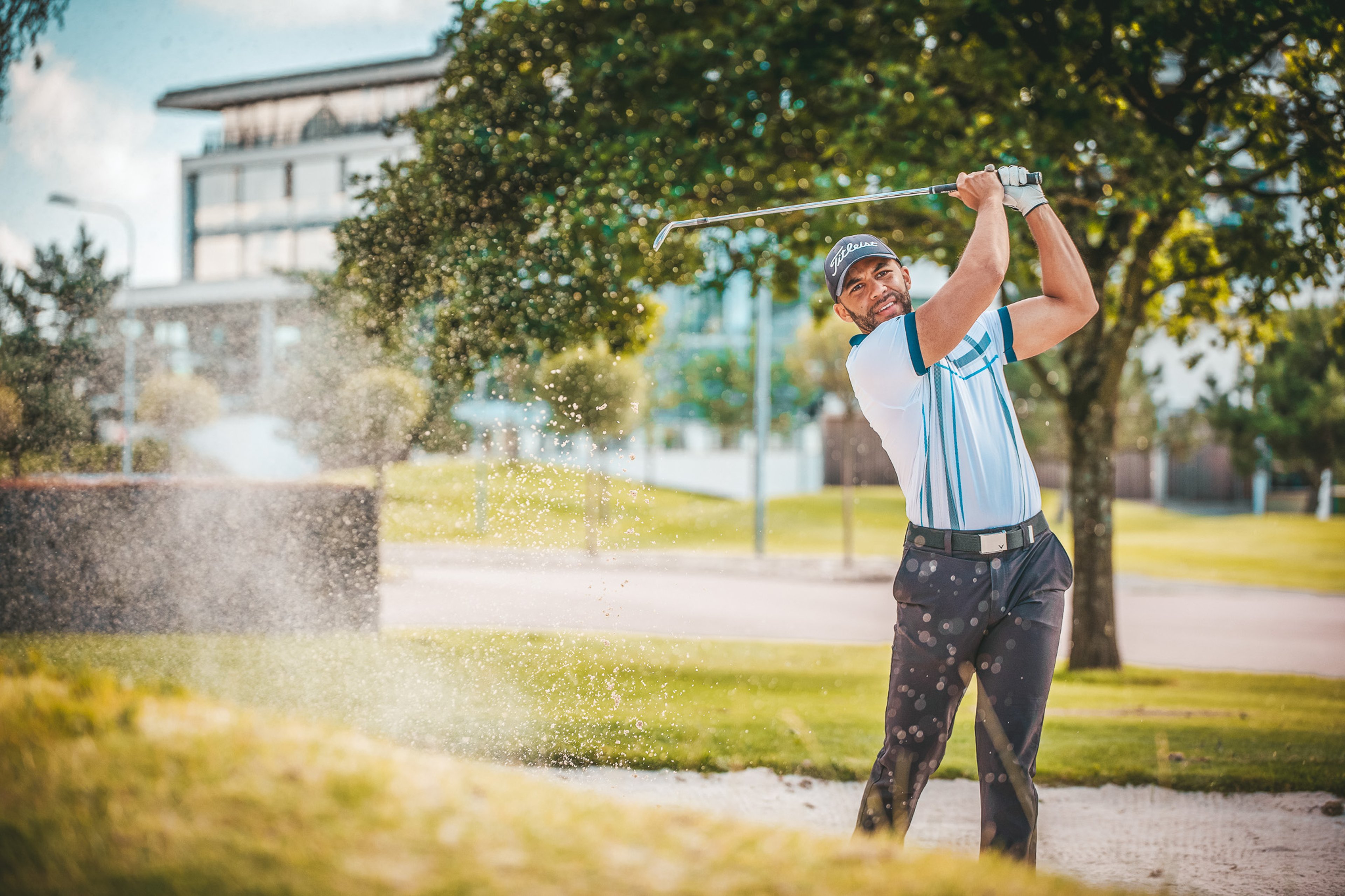 En man med en svingar golfklubba