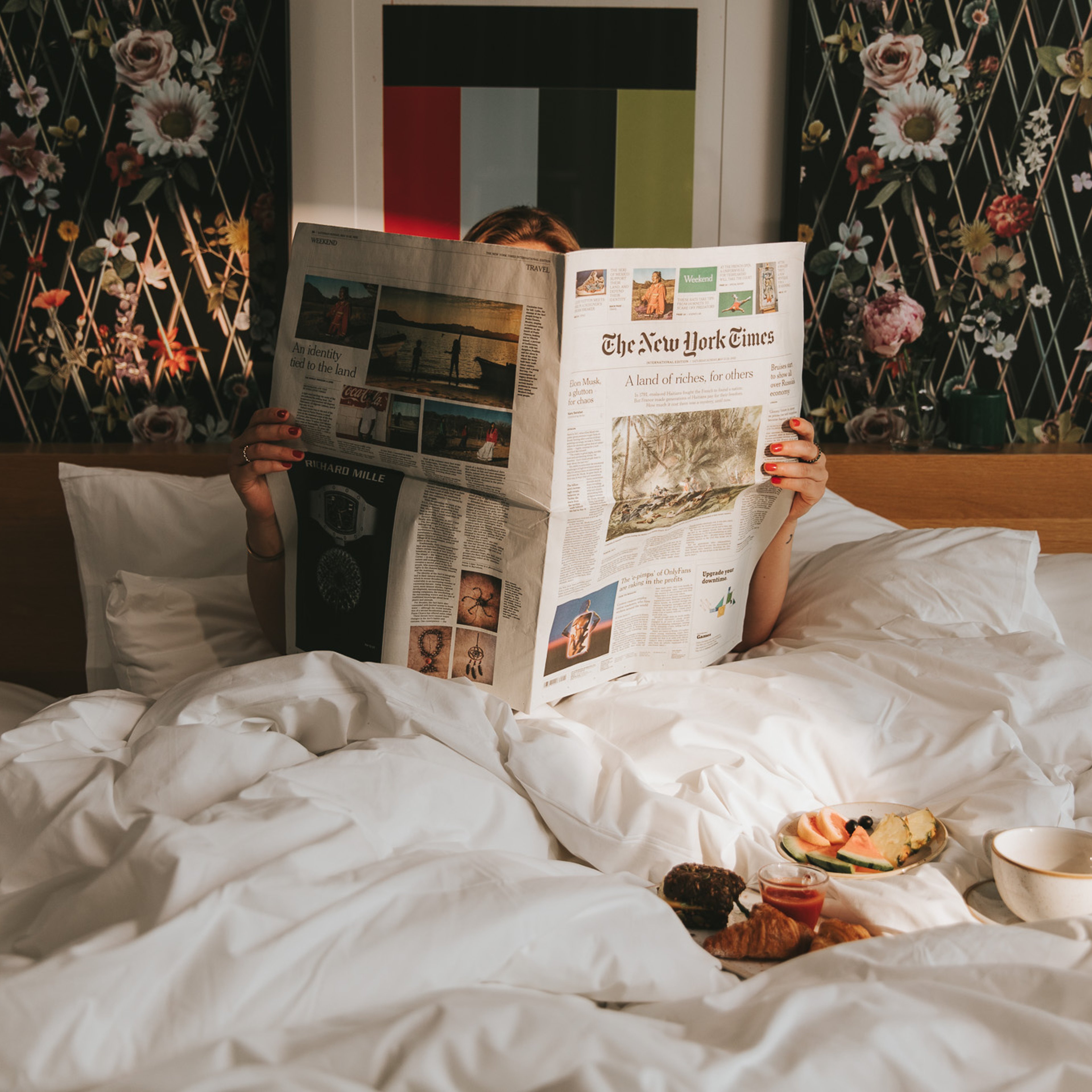 Kvinna som läser tidningen i sängen