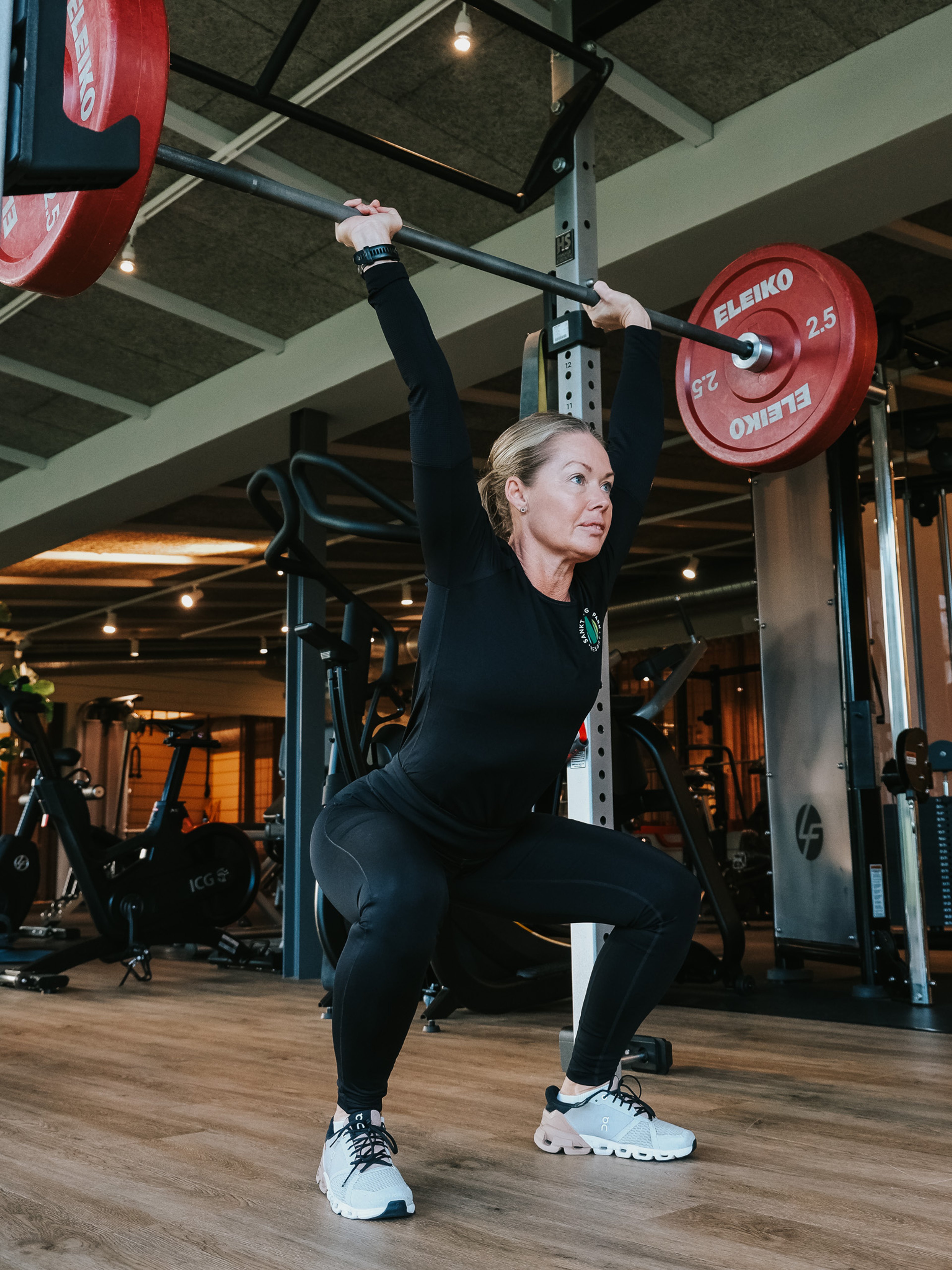 Yogalärare leder en klass med händerna mot himlen