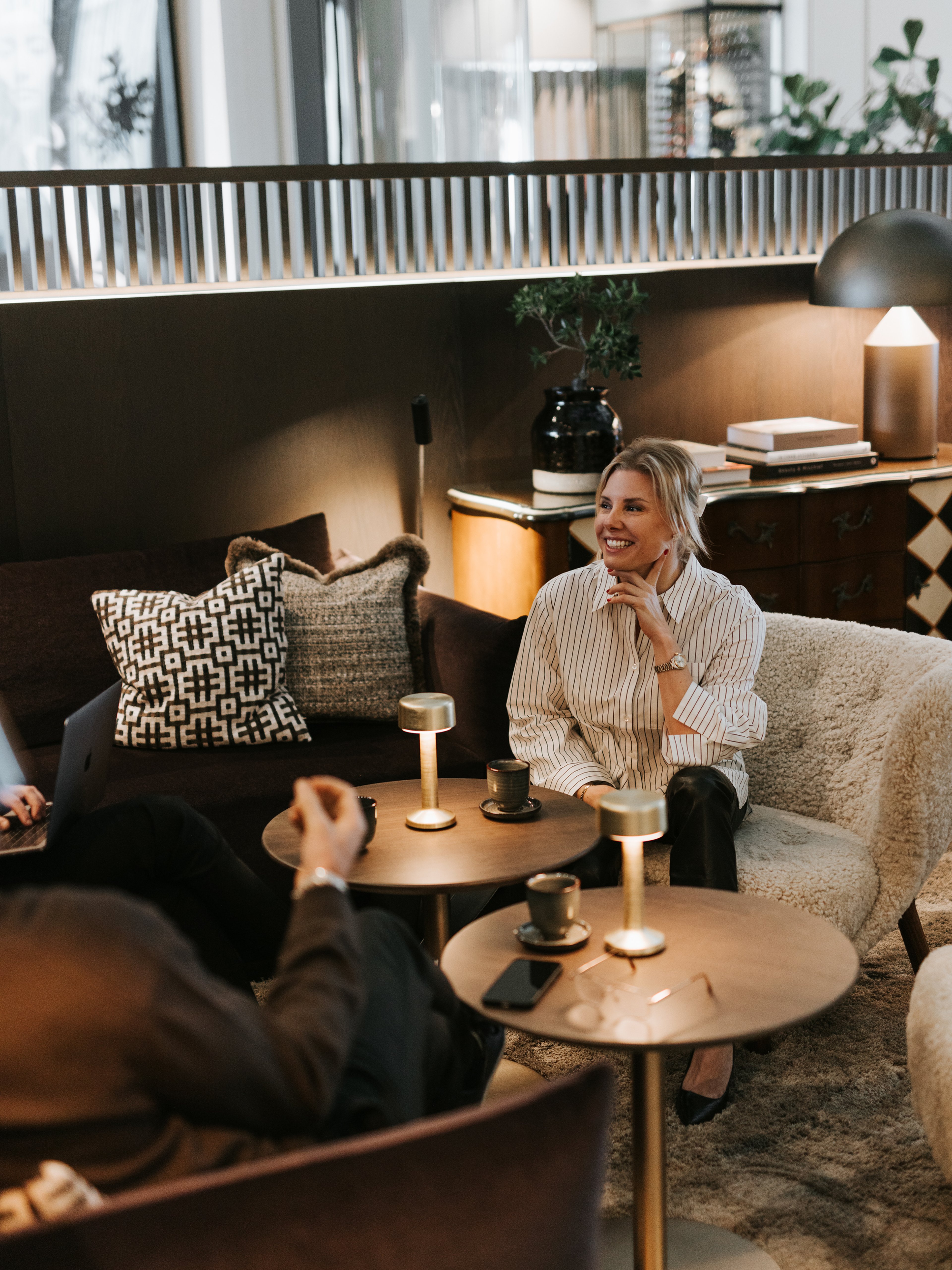 kvinna sitter i en fåtölj och fikar
