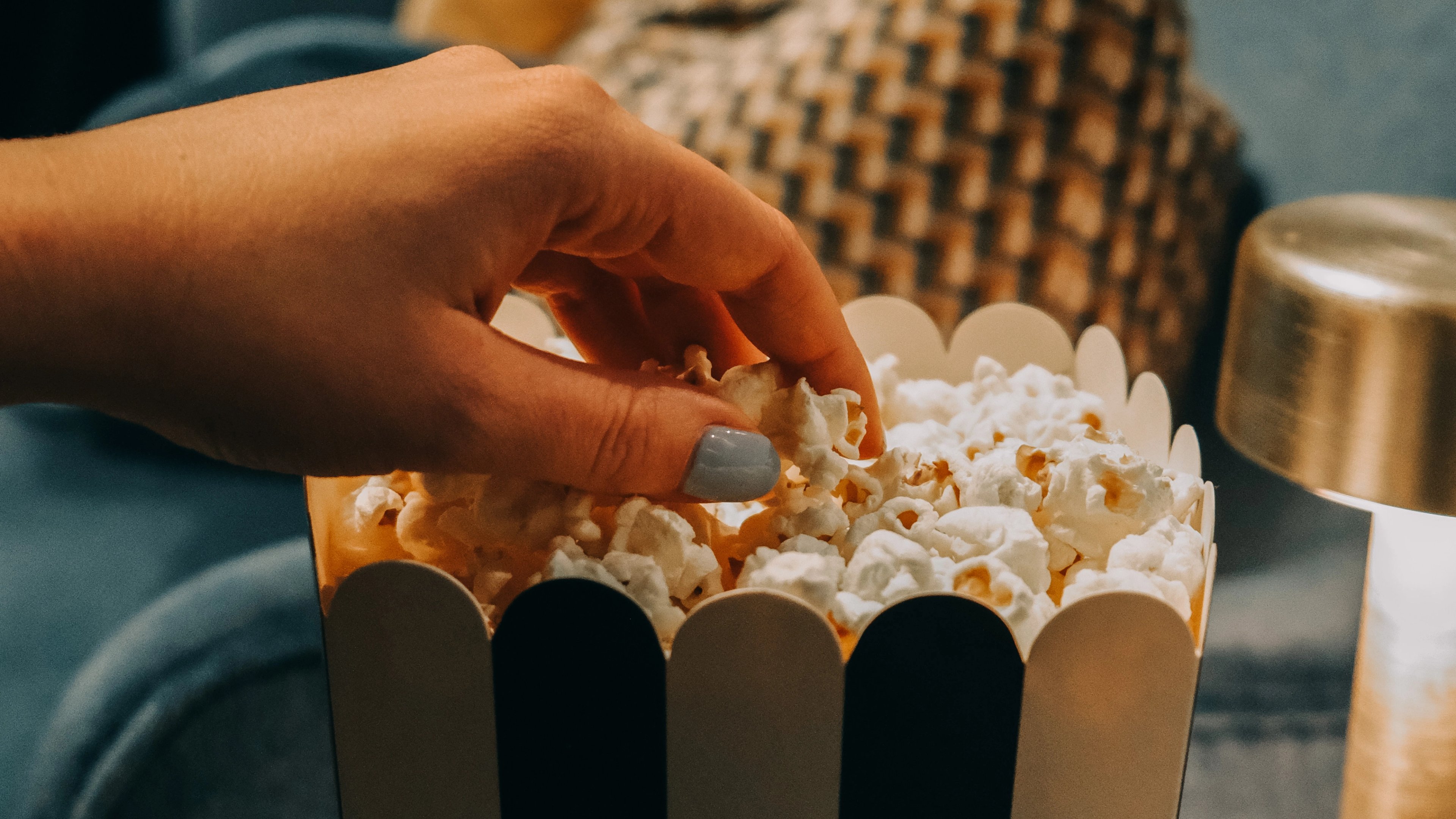En hand som tar popcorn