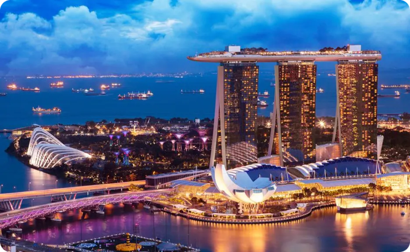 Aerial view of Marina Bay Sands and Gardens by the Bay at night.