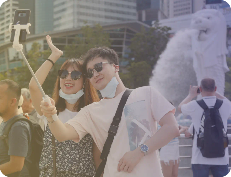 A couple taking a selfie by the Merlion in Singapore