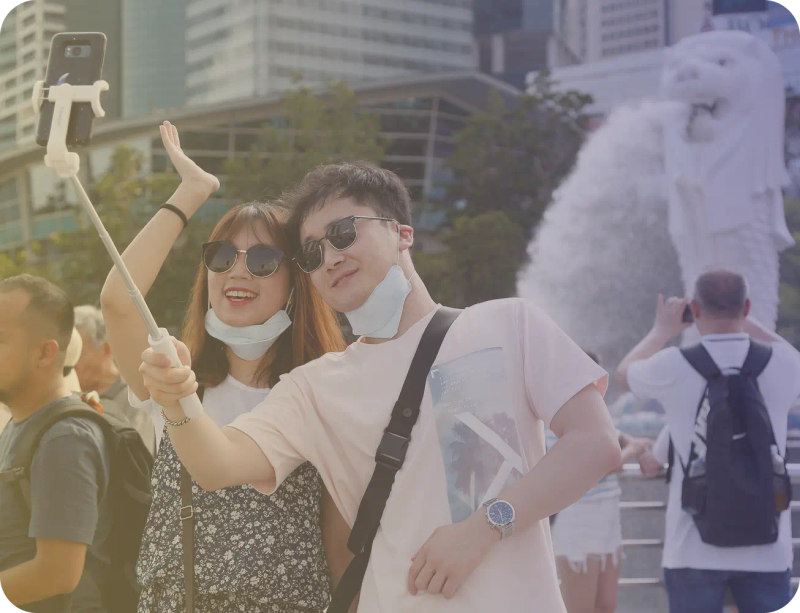 A couple taking a selfie by the Merlion in Singapore