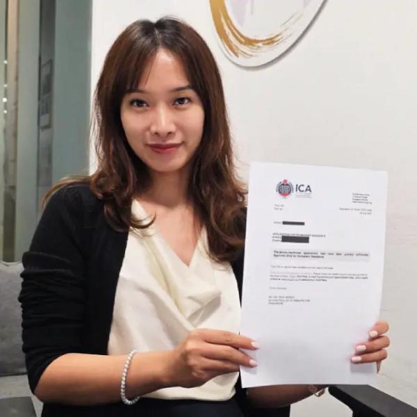 Tracy, a Singapore Top Immigration client, holding their ICA approval letter