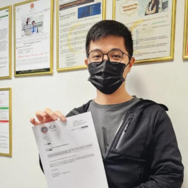 Tran, a Singapore Top Immigration client, holding their ICA approval letter
